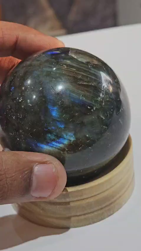 Polished Labradorite sphere gemstone with natural iridescent flash.